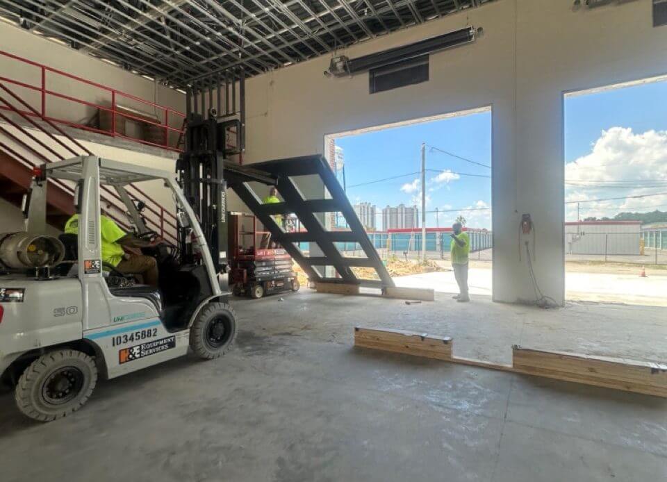 Forklift operator working inside warehouse loading dock with leveler