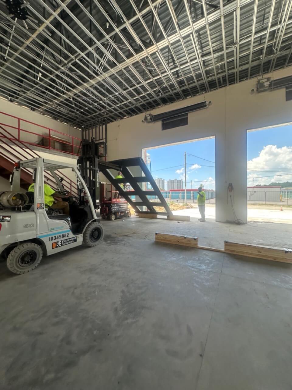 Forklift operator working inside warehouse loading dock with leveler